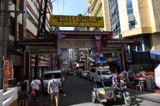 Pedestrians and motorists walk past an arch in Chinatown district of Manila on Jan. 28, 2022, ahead of the Lunar New Year welcoming the Year of the Tiger.