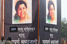 Police personnel stand next to posters of Bollywood playback singer Lata Mangeshkar at Shivaji Park where her funeral was held, in Mumbai on February 7, 2022.
