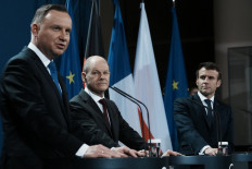 German Chancellor Olaf Scholz (center) listens to Polish President Andrzej Duda (left) during a joint press conference with French President Emmanuel Macron (right), on February 8, 2022 in Berlin. Polish President Andrzej Duda said Tuesday he was confident war could still be averted by easing tensions with Russia over Ukraine, at a Berlin meeting with the leaders of Germany and France.