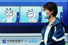 A pedestrian walks past images of the mascot and logo of video streaming site Bilibili in Hangzhou, China, on March 29, 2021.