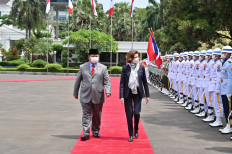 France's Defence Minister Florence Parly (center) and Indonesia's Defence Minister Prabowo Subianto (center-left) review honour guards during a visit at the Defence Ministry in Jakarta on February 10, 2022. 