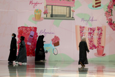 Women walk past shop advertisements ahead of Valentine's day, in Panorama mall in the Saudi capital Riyadh, on February 9, 2022. Red clothing and underwear are displayed in Saudi shops, but the increasingly popular Valentine's Day promotions are missing one thing: the festival's name.