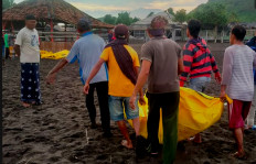 Rescue workers retrieve the bodies of pilgrims who died from drowning on Payangan beach in East Java on Feb. 13, 2022.