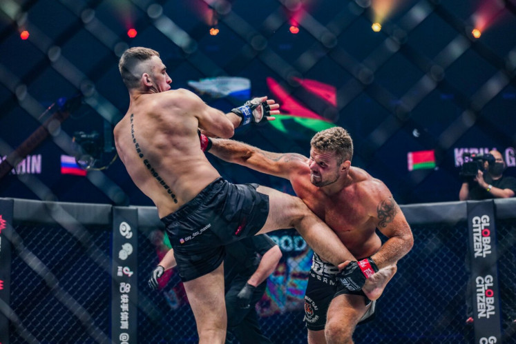 Anatoly Malykhin (right) lands a heavy straight punch on Kirill Grishenko at the main event of ONE: BAD BLOOD on Friday. 