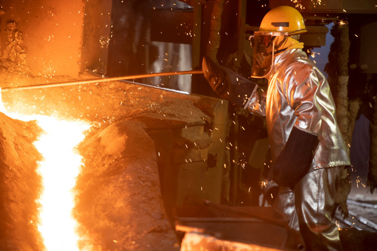 A worker in protective clothing works at a ferronickel smelter owned by PT Aneka Tambang (Antam) in Pomalaa, Central Sulawesi, in this handout photo from May 2019.
