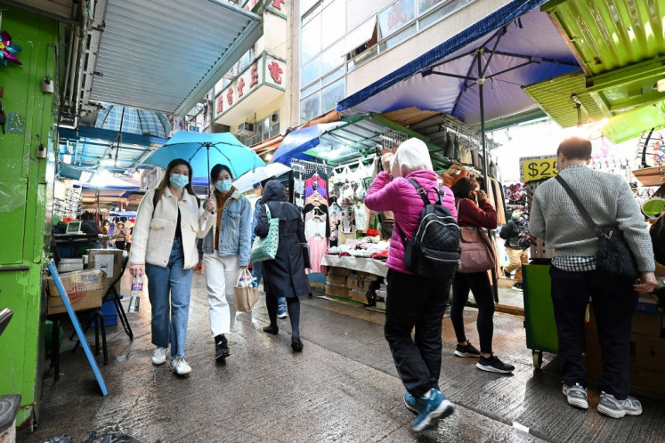 People wear masks on a street in Hong Kong on February 17, 2022, as the city faces its worst Covid-19 outbreak since the start of the pandemic. 