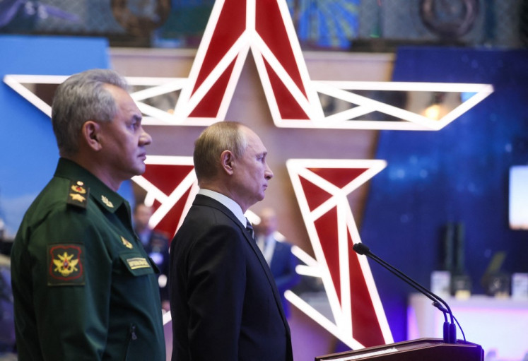 Russian President Vladimir Putin and Defence Minister Sergei Shoigu tour a military gear exhibition before the annual meeting of the Defence Ministry board in Moscow on December 21, 2021.
