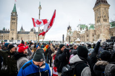 Demonstrators continue their protest as police deploy to remove them on February 19, 2022, in Ottawa, Canada. Police in Canada deployed to dislodge the final truckers and protesters from downtown Ottawa, in a mostly peaceful operation aimed at bringing an end to three weeks of demonstrations over Covid-19 health rules. Ottawa police, who pledged the operation would push ahead 
