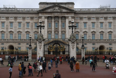 Well-wishers: People gather on Feb. 20, 2022 outside the gates of Buckingham Palace in London. Queen Elizabeth II tested positive on Sunday for COVID-19, but aides said her symptoms were “mild” as politicians wished Britain’s longest-serving monarch a rapid recovery in her 70th year on the throne.