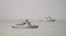 A handout photo taken on February 18, 2022 and received on February 20, 2022 shows a Chinese PLA-N Luyang-class guided missile destroyer (L) and a PLA-N Yuzhao-class amphibious transport dock vessel (R) leaving the Torres Strait and entering the Coral Sea after the Australian Defence Force confirm that on 17 February 2022, a Royal Australian Air Force (RAAF) P-8A Poseidon detected a laser illuminating the aircraft from a People’s Liberation Army – Navy (PLA-N) vessel. 