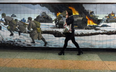 A woman walks past a wall decorated with a mosaic depicting a World War Two battle scene in an underground passage in the southern city of Rostov-on-Don - the major city of the Rostov region bordering Ukraine, on February 22, 2022.
