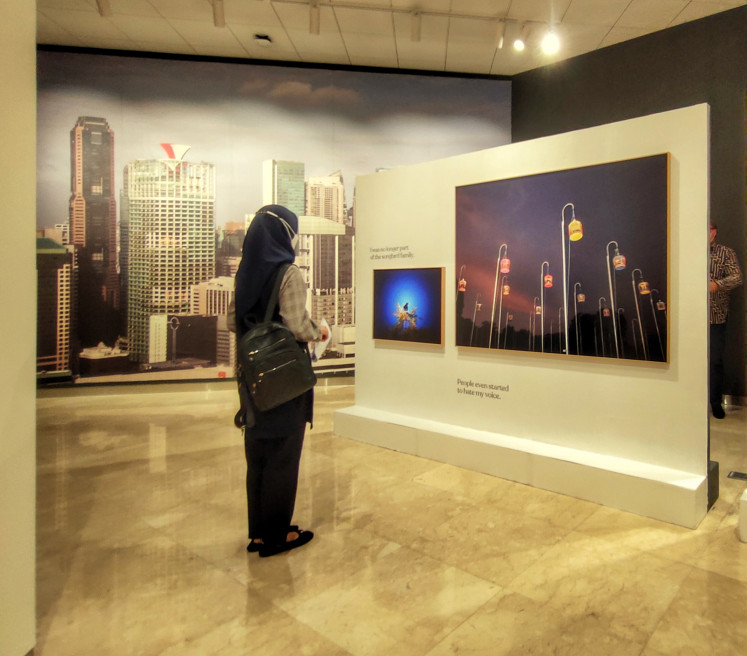 Caged: A visitor of the exhibition was savoring a picture of Javan mynas in cages. (JP/Sylviana Hamdani)