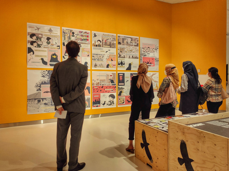 Picture perfect: A visitor of the exhibition was savoring a picture of Javan mynas in cages. (JP/Sylviana Hamdani)