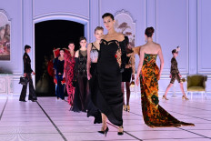 Fashion as distraction: United States model Bella Hadid (front) and other models present creations during the Moschino catwalk show for the Fall/Winter 2022/2023 collection on Feb. 24, 2022, the third day of Milan Fashion Week in Milan, Italy.