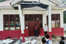 Residents inspect a building damaged by a magnitude 6.2 earthquake at Kajai village in West Pasaman on February 25, 2022. 
