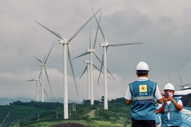 Officials take photos of wind turbines belonging to state-owned power company PLN in Sidrap, in Sidenreng Rappang, South Sulawesi, on Oct. 26, 2021. With 30 turbine generators, this is the largest wind power plant in Indonesia.