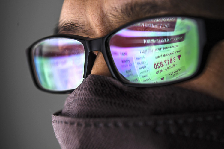 Eyeing the market: A man watches stock price movements on a screen on Feb. 24, 2022, in Jakarta.