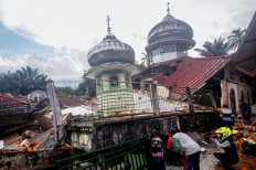 Villagers try to communicate with the victims under the rubble of a mosque, in West Pasaman, on February 25, 2022, after a magnitude 6.2 earthquake hit the area and damaged hundreds of houses and public facilities. 