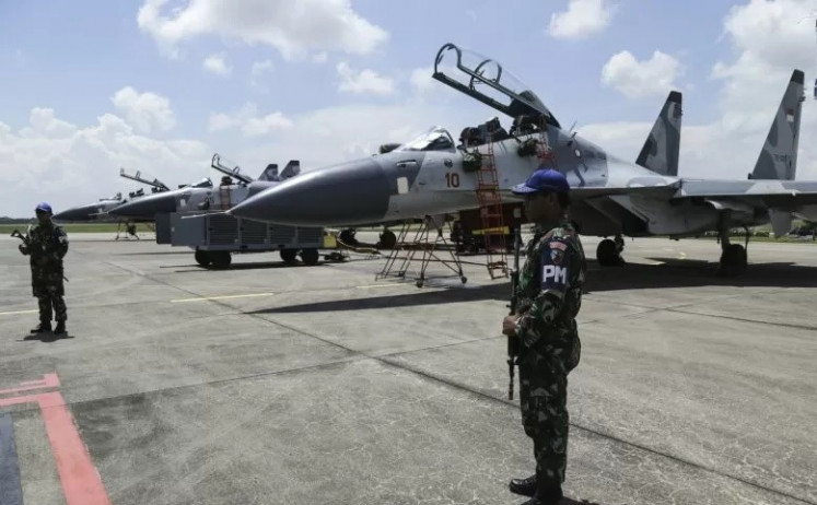 Air Force personnel stand guard near three Sukhoi Su-27 and Su-30 fighter jets arriving from Sultan Hasanuddin airbase in Makassar at Hang Nadim Airport in Batam, Riau Islands on Oct. 30, 2018. 