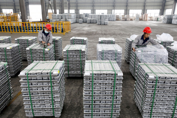 Employees work with aluminum ingots on Feb. 9, 2022, at a factory in Huaibei in China's eastern Anhui province.