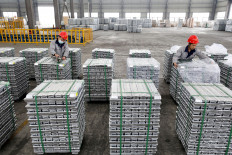 Employees work with aluminum ingots at a factory in Huaibei in China's eastern Anhui province on Feb. 9, 2022.