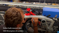 CEO of Brompton Will Butler-Adams signs a limited-edition bicycle for a fundraising auction for an Indonesian mosque in London.