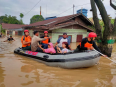 Search and rescue personnel evacuate residents affected by floods in Medan, North Sumatra, on Feb. 27.