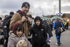 Ajmal Rahmani from Afghanistan and his children are seen as refugees from many different countries - from Africa, Middle East and India - mostly students of Ukrainian universities are seen at the Medyka pedestrian border crossing fleeing the conflict in Ukraine, in eastern Poland on February 27, 2022. As Ukraine braces for a feared Russian invasion, its EU member neighbours are making preparations for a possible influx of hundreds of thousands or even millions of refugees fleeing military action.