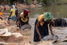 Artisanal miners collect gravel from the Lukushi river searching for cassiterite on February 17, 2022 in Manono.