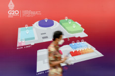 An organizing committee member passes in front of a floor plan of the rooms used for the G20 Finance Minister and Central Bank Governors Meeting at the Jakarta Convention Center on Feb. 16, 2022.
