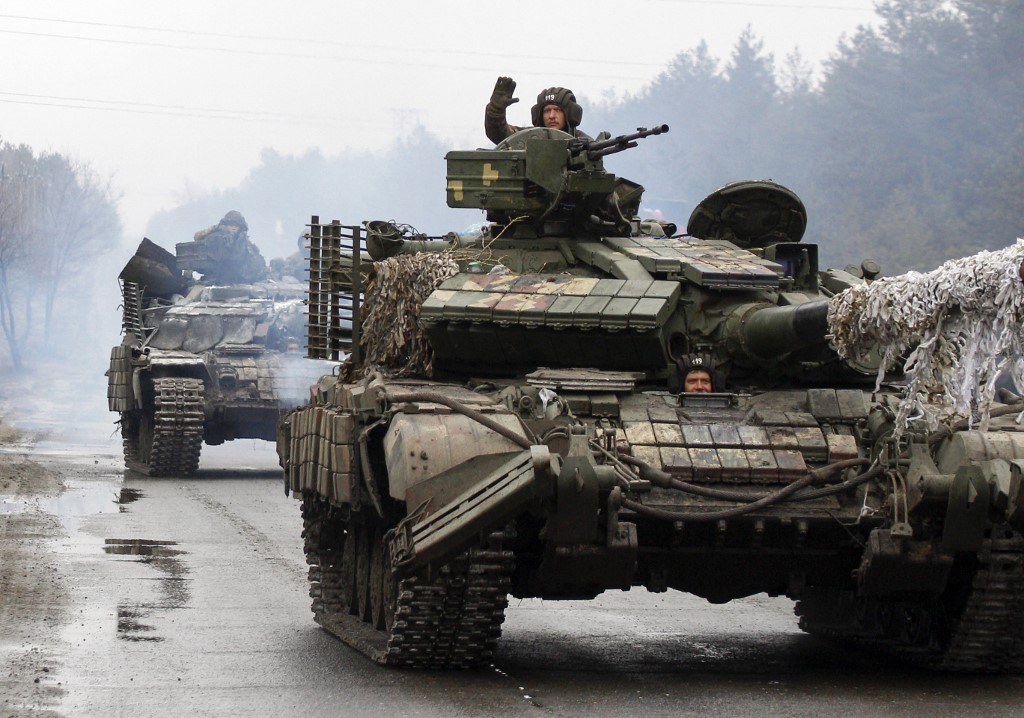 Ukrainian servicemen ride on tanks towards the front line with Russian forces in the Lugansk region of Ukraine on February 25, 2022. 