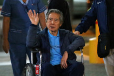 In this file photo taken on January 04, 2018 Peru's former President Alberto Fujimori waves to supporters as he is wheeled out of the Centenario Clinic in Lima.