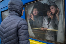 Between life and death: A family on an evacuation train says goodbye to a young man staying on the platform at the central train station in Odessa, Ukraine, on Sunday. Ukrainian President Volodymyr Zelensky warned that day that Russian forces were preparing to bombard the port city.

