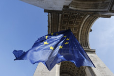 A photograph taken on March 10, 2022 shows the European Union flag flying under the Arc de Triomphe, on the Place de l'Etoile in Paris.