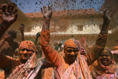 Widows smeared with Gulal (colour powder) dance as they participate in Holi celebrations, the Hindu spring festival of colours, at a temple in Vrindavan on March 15, 2022.