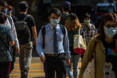 People cross a street in the financial district in Hong Kong, China, on March 15, 2022.