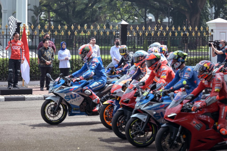 MotoGP riders are flagged off by Indonesia's President Joko 'Jokowi' Widodo (left) at the start of a motorcycle parade in downtown Jakarta on March 16, 2022, ahead of this weekend's MotoGP Indonesia Grand Prix. 