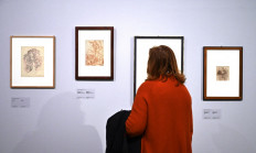 A visitor views drawings by (From L) Belgian artist Henri Michaux (1944), Italian Baroque painter Simone Cantarini (1644-1648) and Italian Renaissance artist Stefano Della Bella (1648) at the exhibition 'Scribbling and Doodling: From Leonardo da Vinci to Cy Twombly' on March 17, 2022 at the Villa Medici, The French Academy in Rome.