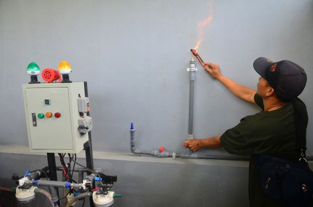 Green energy: A technician checks methane gas produced by a biomass reactor on March 4, 2022, in Gondosari village, Kudus regency, Central Java. The bioreactor installation converts agriculture and animal husbandry waste into energy, fertilizer and pesticide.

