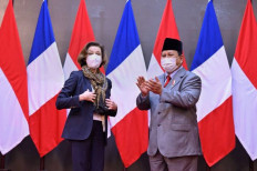 Scarf diplomacy: France's Defense Minister Florence Parly (left) wears a new scarf she received from her Indonesian counterpart Prabowo Subianto (right) during a signing ceremony for a memorandum of understanding between the two countries at the Indonesian Defense Ministry in Jakarta on Feb. 10.