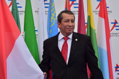 Indonesia's G20 co-sherpa, Dian Triansyah Djani, shows Indonesian national flag as he arrives to attend the 10th Asia-Europe Meeting (ASEM) on October 16, 2014 in Milan. 