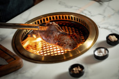 Blazing fire: A rib-eye is grilled on the table-top grill in Sudestada's new private room. (Courtesy of Sudestada Jakarta)