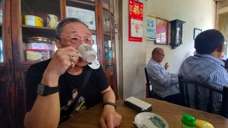 Leisure time: Suyanto Husein, a resident of Medan Chinese descent, enjoys coffee at Apek Kopitiam. (JP/Tonggo Simangunsong)