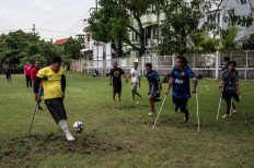 This picture taken on March 25, 2022 shows disabled football player Syaiful Arifin (L) attending football practice with his team in Surabaya. Syaiful Arifin loved football as a child but thought his playing days were over when he lost his left leg at the age 12 after falling off a train.