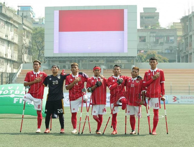 National triumph: Players of the Indonesian Amputee Football Association (INAF) salute the Indonesian national anthem before kickoff at an East Asia Qualifier match in Dhaka, Bangladesh. INAF finished runner-up in the qualifier after a 0-2 first-time loss to Japan to earn a spot at the 2022 Amputee Soccer World Cup, to be held in October in Turkey. (Courtesy of INAF)