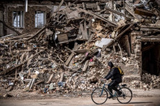 War zone: A man rides a bicycle past the rubble of a destroyed building in the eastern Ukraine city of Kharkiv on Saturday, as Ukraine said Russian forces were making a 