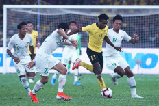 Malaysia's Mohamadou Sumareh (center) fights for the ball with Indonesian players during the Qatar 2022 FIFA World Cup qualifying football match between Malaysia and Indonesia at the Bukit Jalil Stadium in Bukit Jalil on November 19, 2019. 