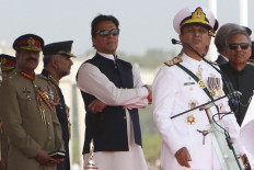 Pakistan's Prime Minister Imran Khan (center) and President Arif Alvi (right) watch Pakistan's Air Force fighter jets perform during the Pakistan Day parade in Islamabad on March 23, 2022. 
