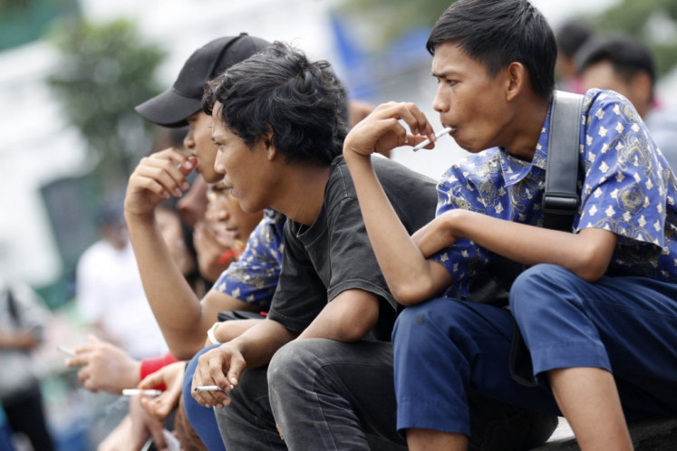 Hang out: An Indonesian youth smokes a clove cigarette in Jakarta on April 7, 2012. (AFP/Oscar Siagian)