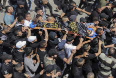 Mourners carry the body of 25-year-old Palestinian Ahmed al-Saadi, who was killed earlier during clashes with Israeli forces, during the funeral in the Palestinian refugee camp of Jenin in the occupied West Bank on April 9, 2022.